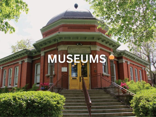 Historic red-brick museum building with a domed roof and garden.