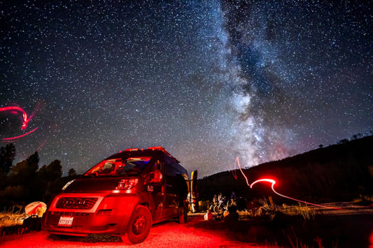 Van parked under a starry sky with the Milky Way visible in the background.