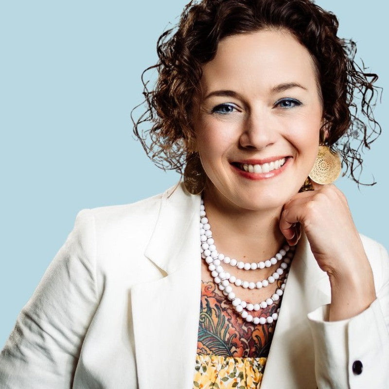 Portrait of a woman with curly hair and pearls, smiling