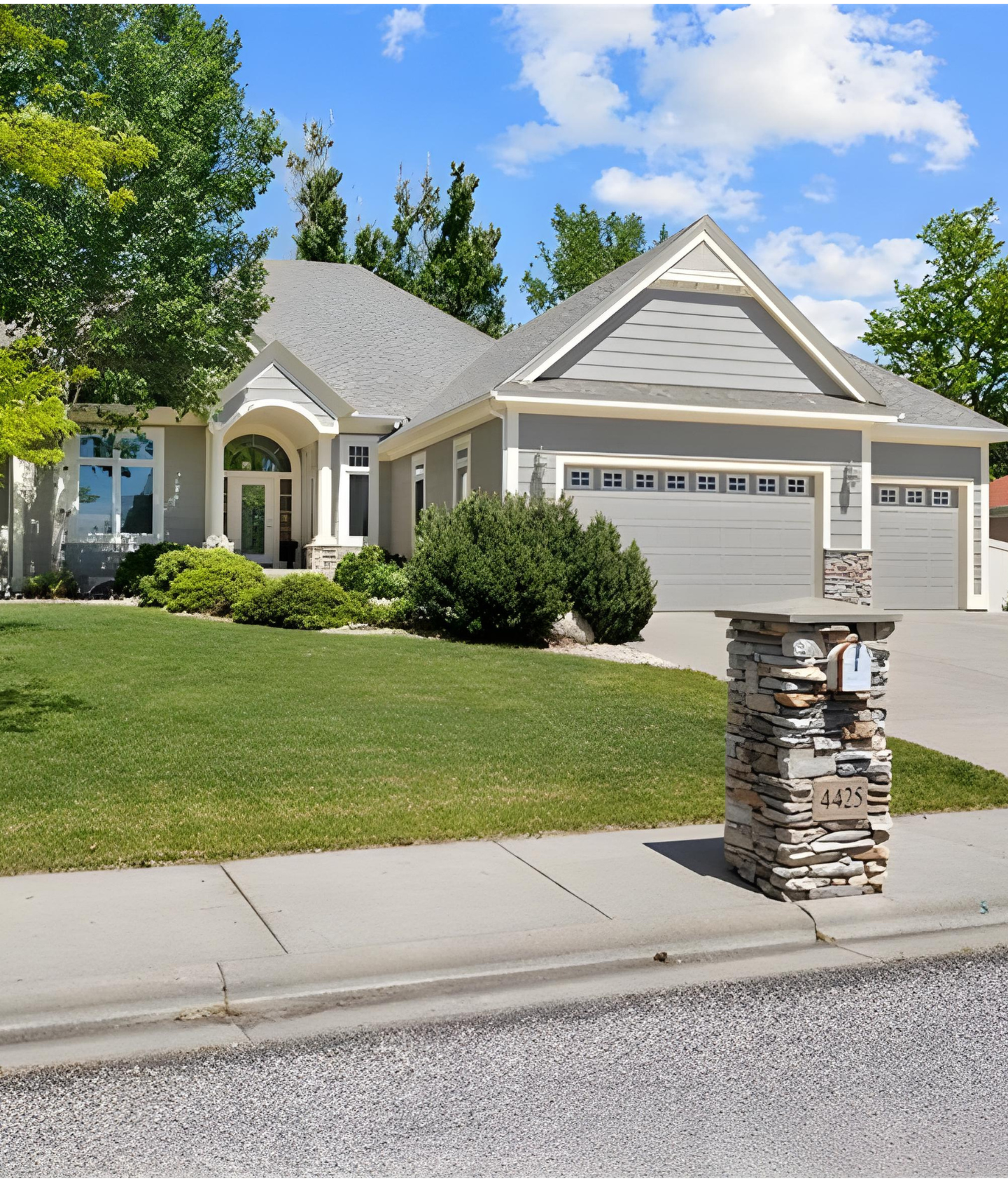 A residence with a generous driveway and a stone column