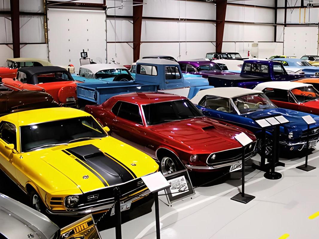 Collection of classic cars and trucks displayed in an indoor museum.