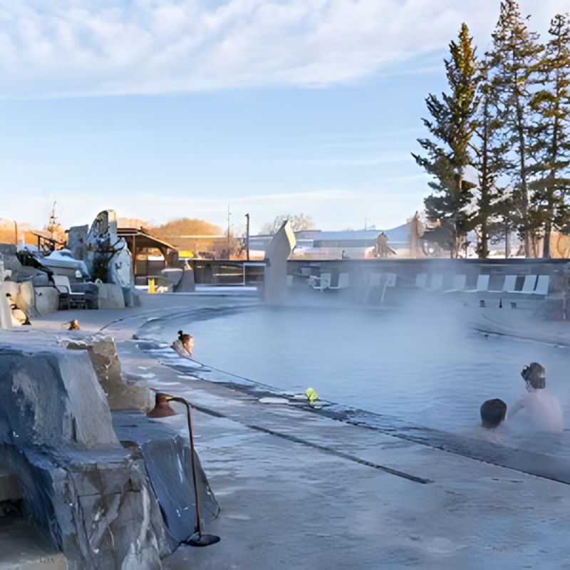  Visitors delight in the warm, therapeutic waters of a hot springs resort, enjoying a serene and rejuvenating experience.