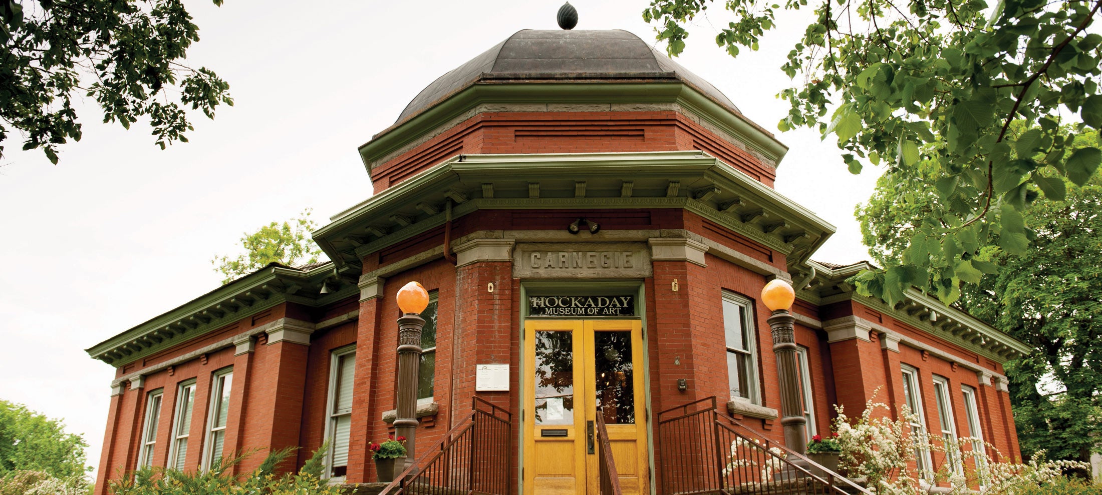 A red brick edifice with a cheerful yellow door, exemplifying a charming and inviting architectural style.