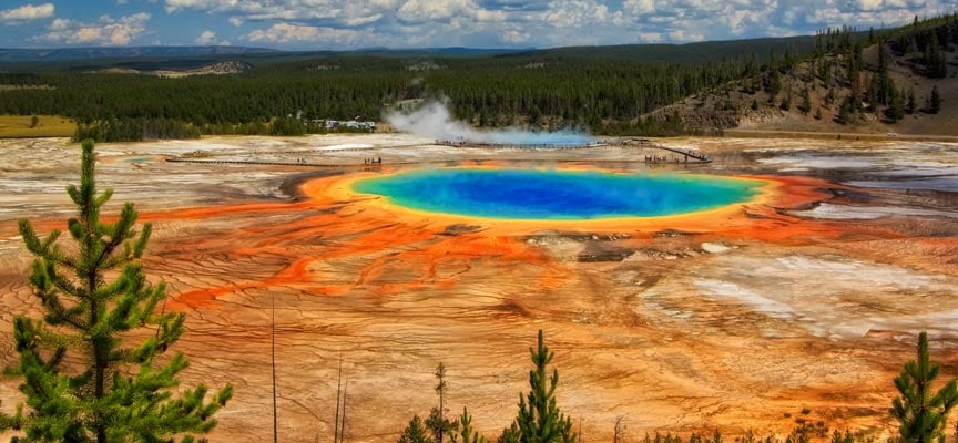 A vibrant view of the Grand Prismatic Spring in Yellowstone National Park, showcasing its colorful thermal waters and surrounding landscape.