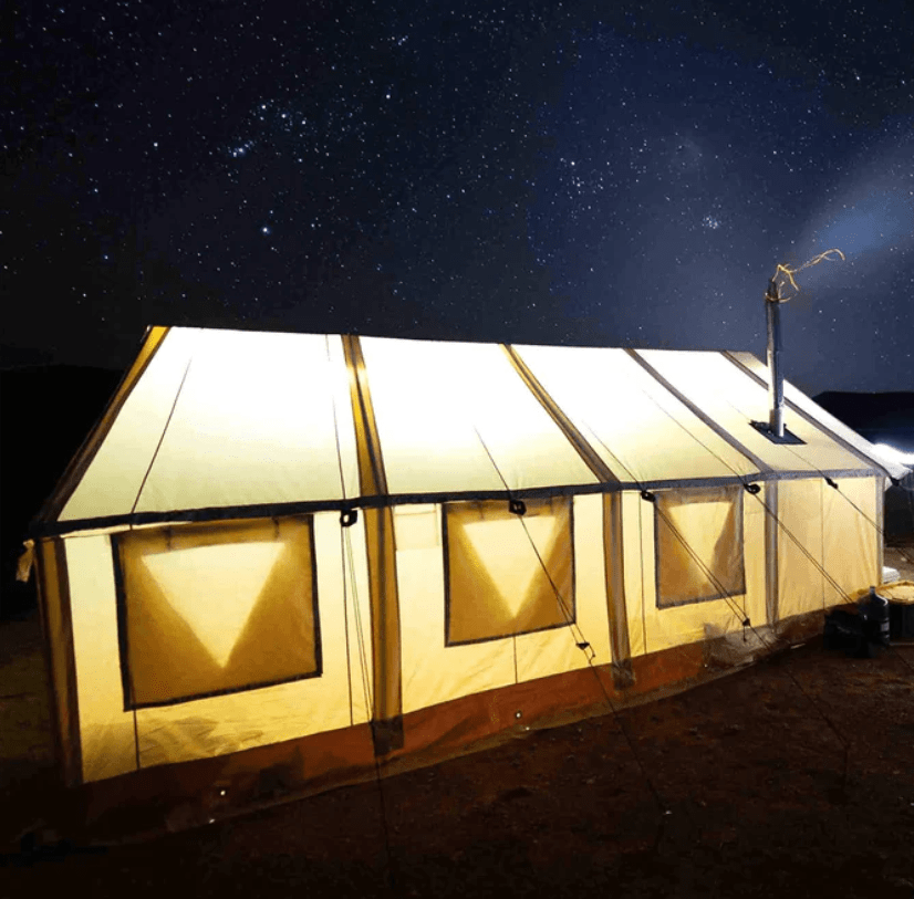 A brightly lit tent under a starry night sky.